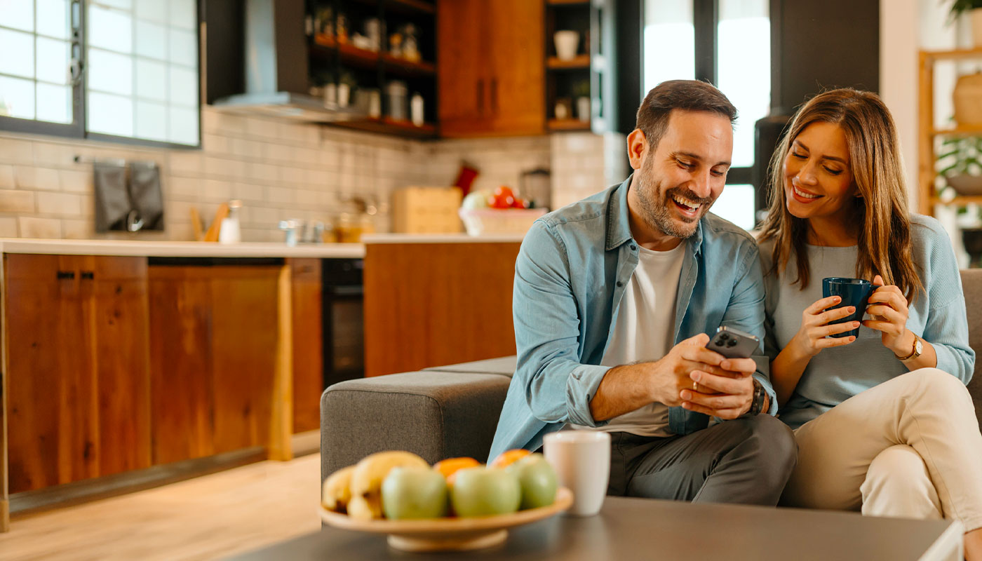 coppia sul divano guarda smartphone